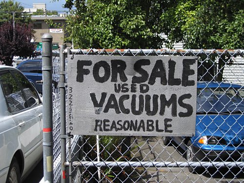[Sign: "For Sale/Used Vacuums/Reasonable"]